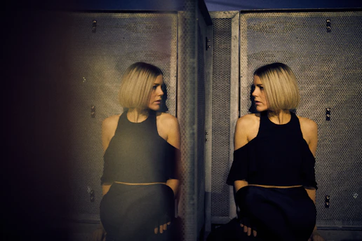 woman leaning on wall looking beside mirror
