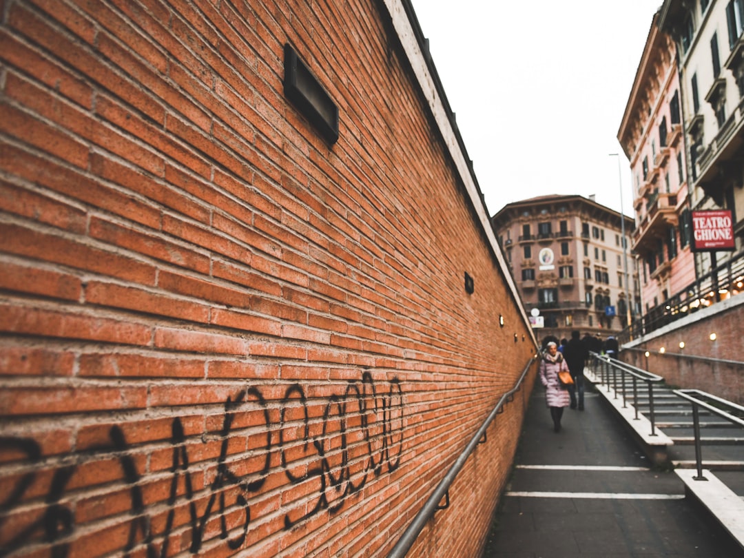 woman walking on alley beside stairway