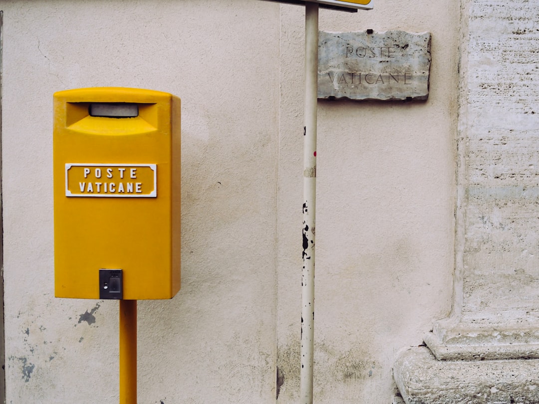 yellow poste vaticane meter beside white wall