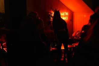 Participants solving clues together while enjoying retro cocktails under warm, amber lighting.