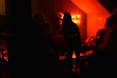 Participants solving clues together while enjoying retro cocktails under warm, amber lighting.