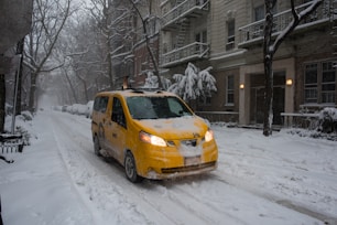 yellow sedan on snow covered road during daytime