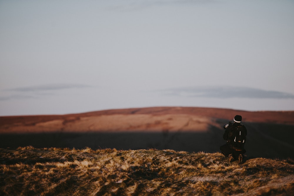 uomo che scatta foto di campo aperto marrone