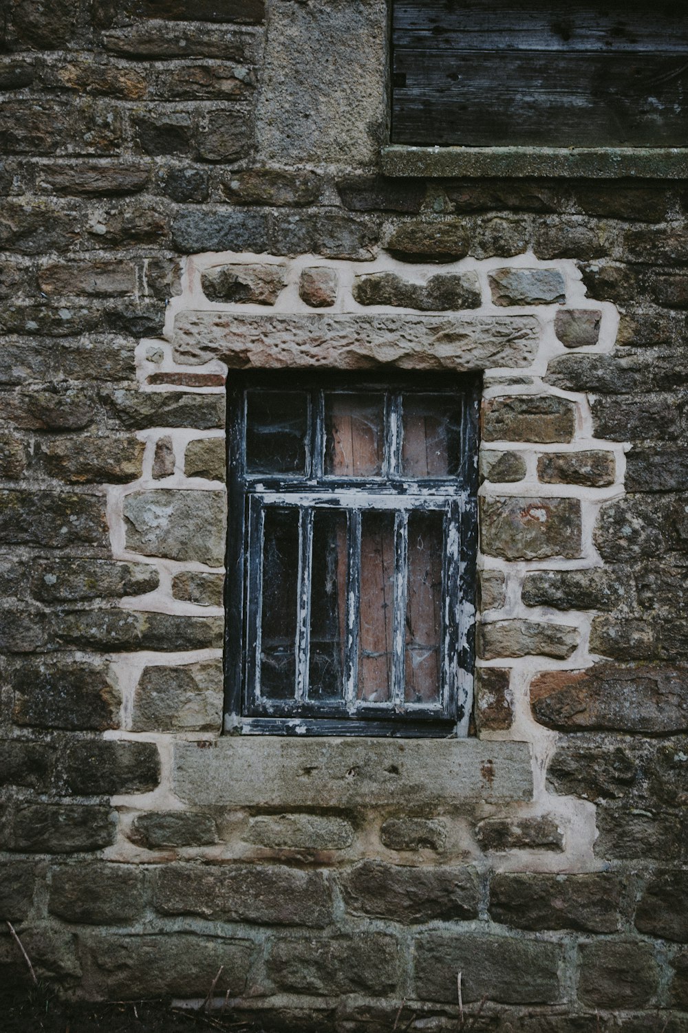 janela do painel de vidro de madeira preta na parede de tijolo cinza