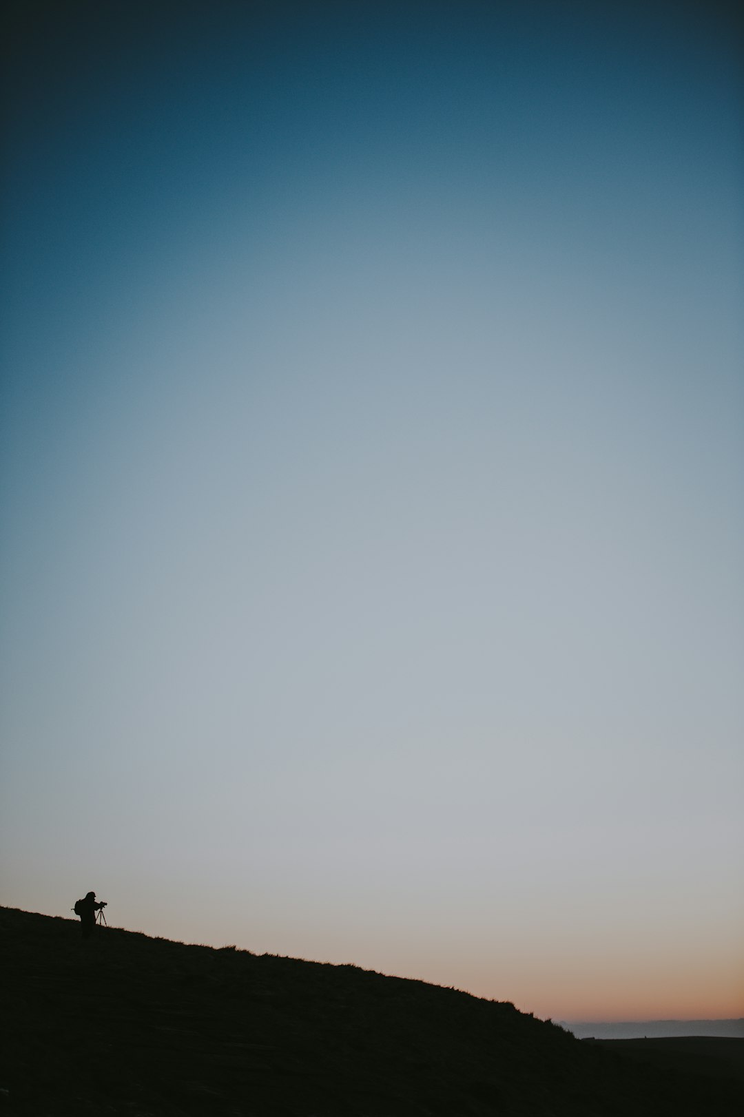 silhouette of person on top of a hill