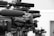 A close-up view of a row of professional television cameras equipped with large microphones, all lined up and focused in the same direction, suggesting a press conference or media event.