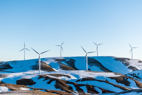 windmills surrounded by snow-covered field during daytime