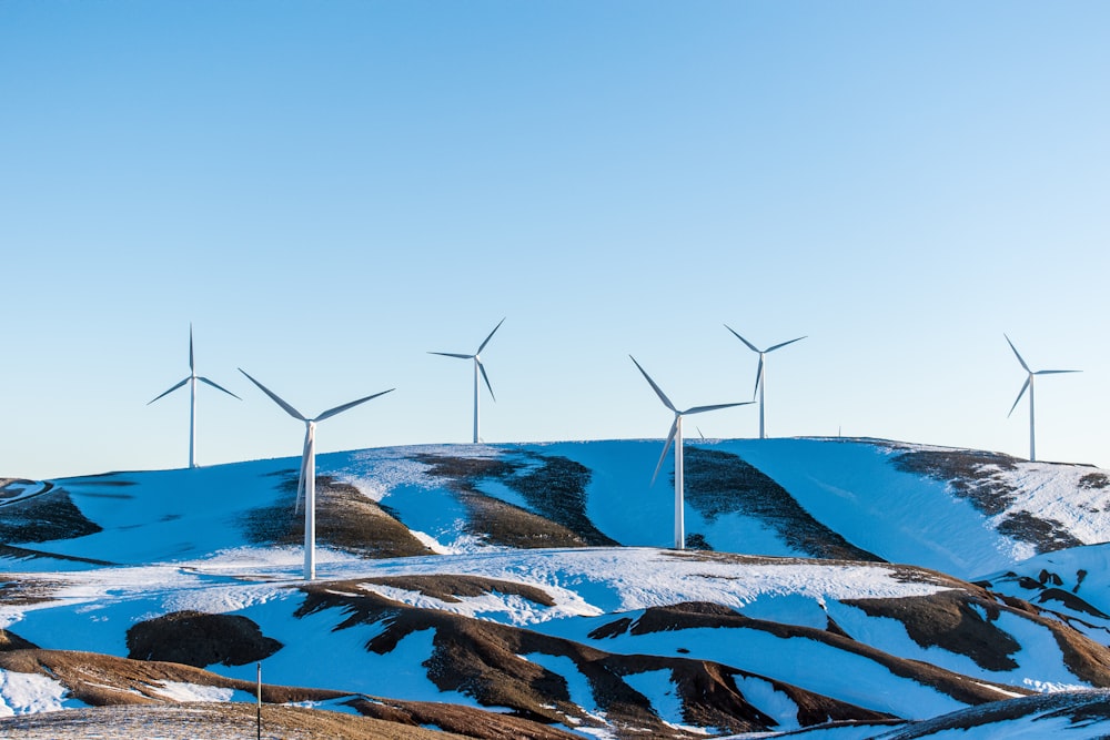 windmills surrounded by snow-covered field during daytime