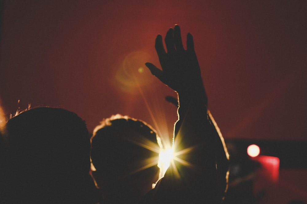 silhouette of man raising his hands inside deemed room