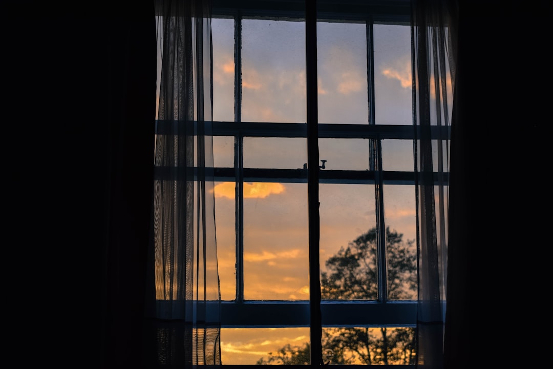  photo of blue framed glass window with curtain door frame