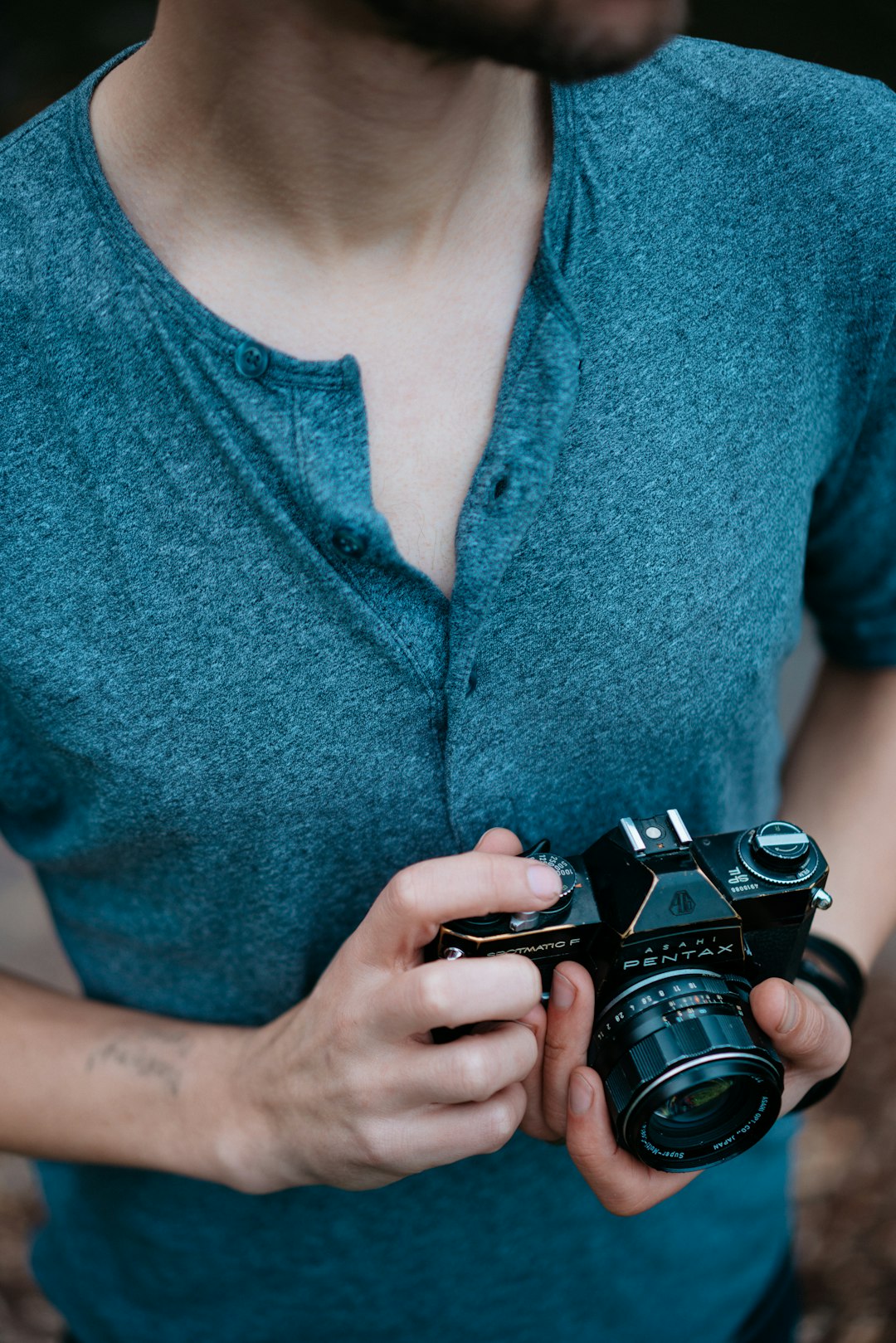 man holding Pentax SLR camera