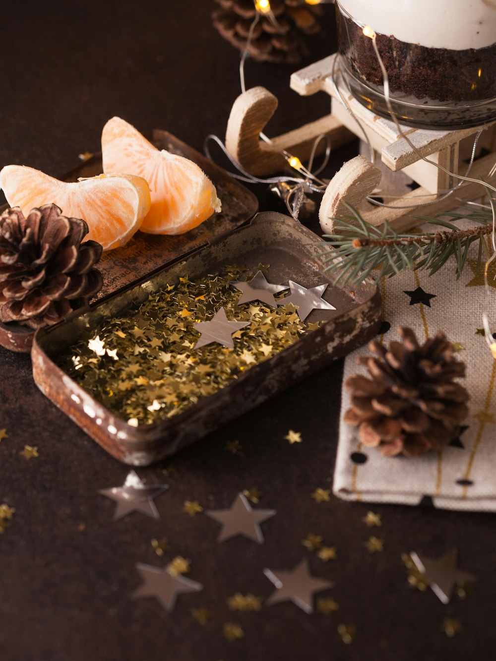 two sliced citrus fruits on brow tray beside pinecone