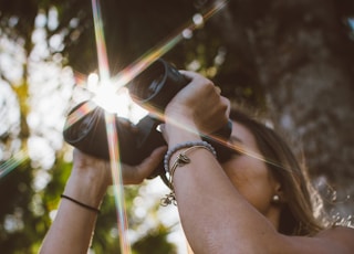 woman using binoculars in forest