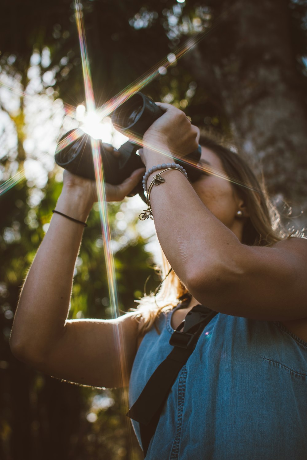 woman using binoculars in forest