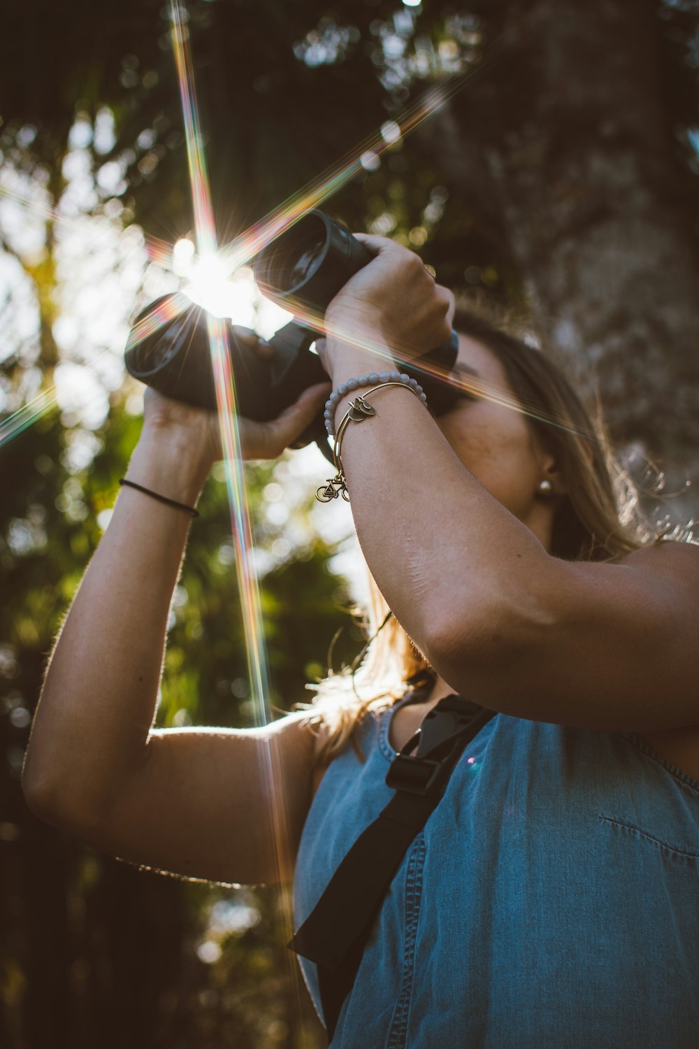 Femme utilisant des jumelles dans la forêt