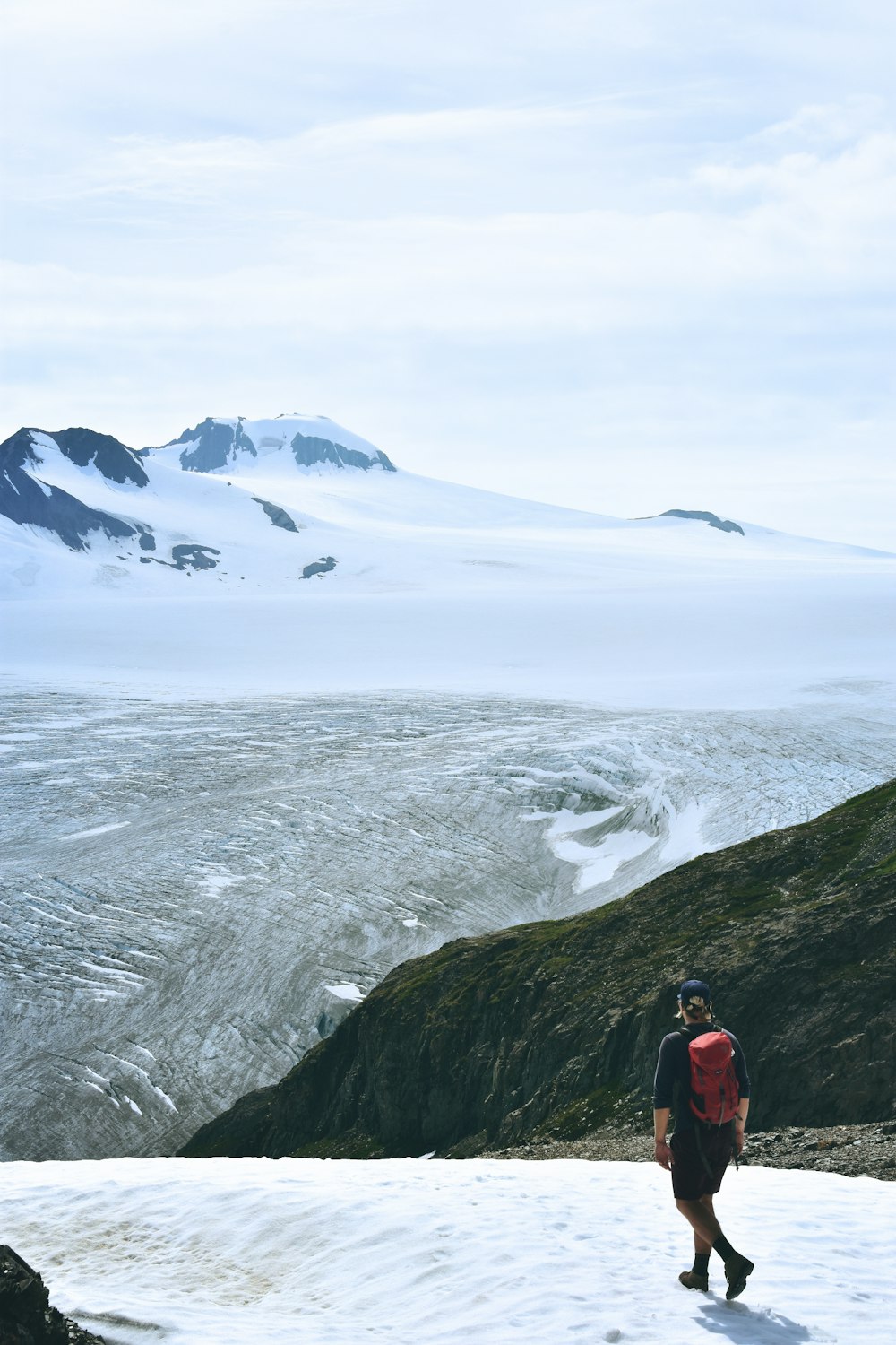 man walking on snow facing mountain