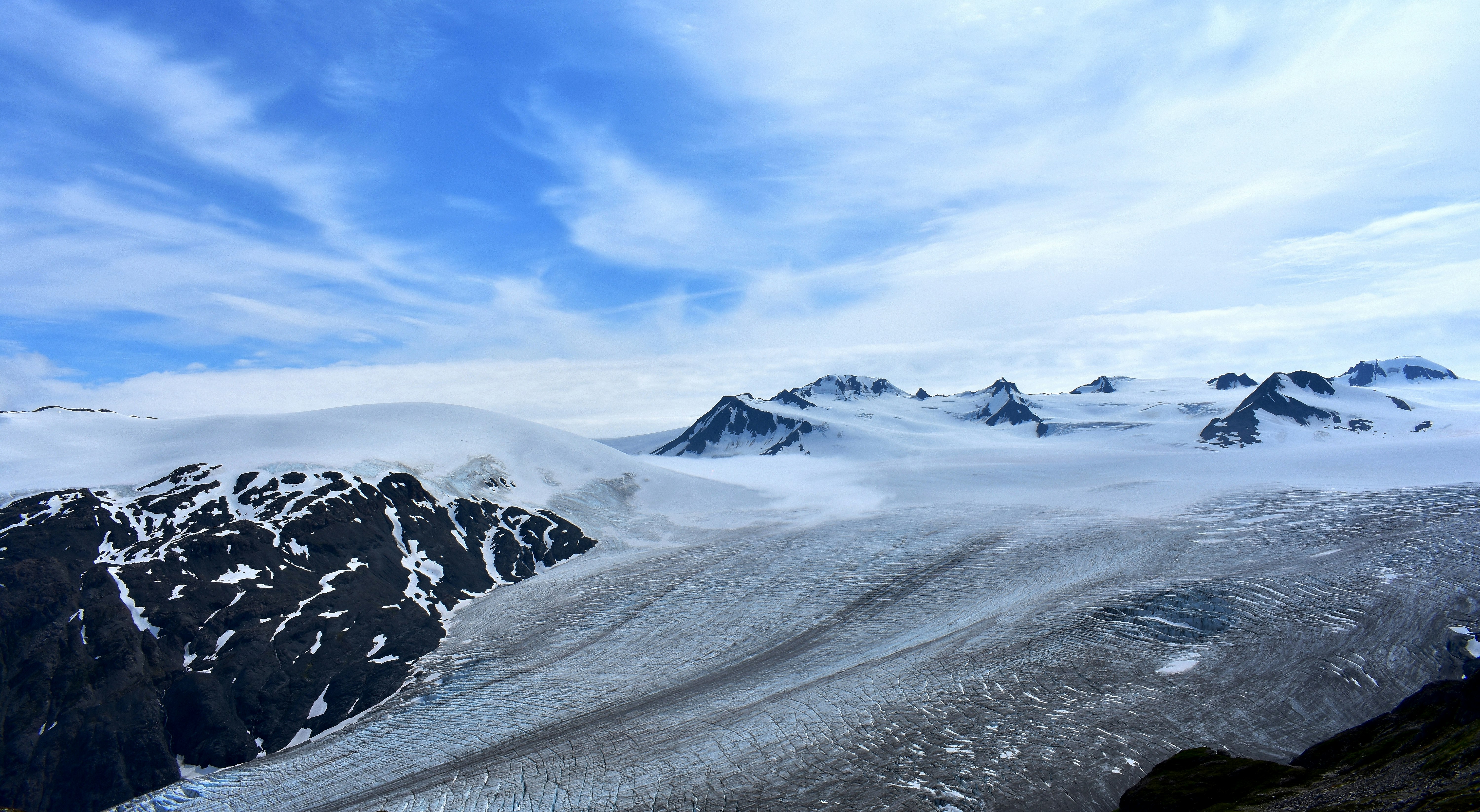 mountain covered with snow under white clouds