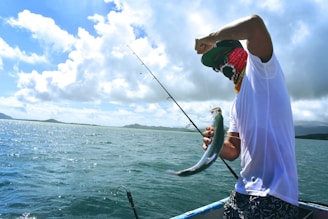 man in white t-shirt holding a fish