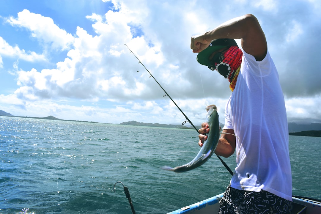 man in white t-shirt holding a fish, popio