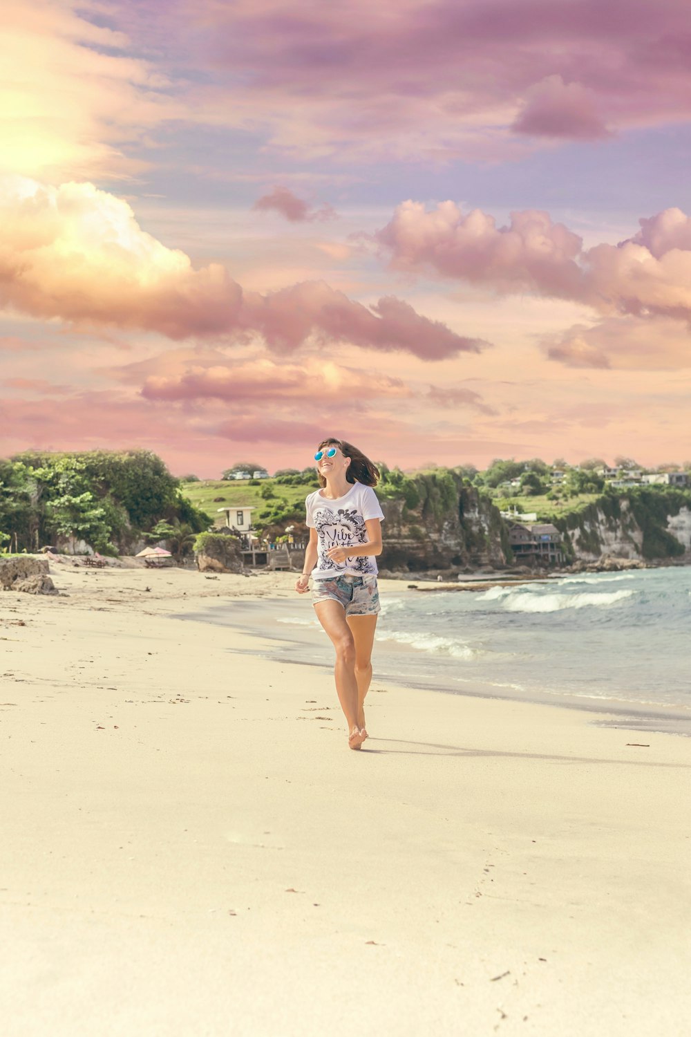 woman running on sea shore near body of water