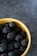Close-up of a smiling woman holding a bowl of fresh blackberries from Fruta Santa.
