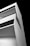 A modern, minimalist architectural structure with angular lines and large, dark windows. It is composed of white concrete and is set against a stark, black background, enhancing its geometric design.