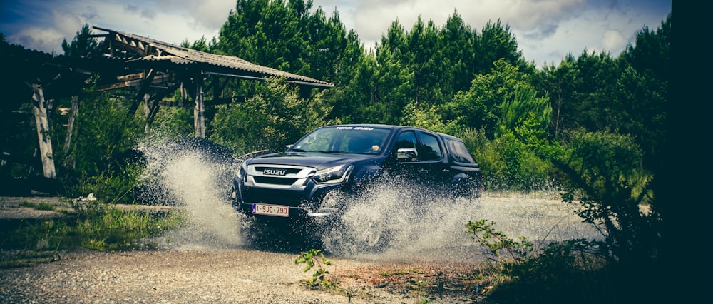 Attraversamento nero del camioncino con cabina dell'equipaggio sull'acqua