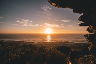 A sunset view from a cliff overlooking the ocean.