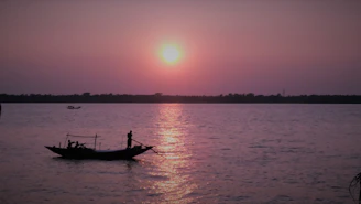 A small group enjoying a boat ride along the Rio de Janeiro coastline during sunset.