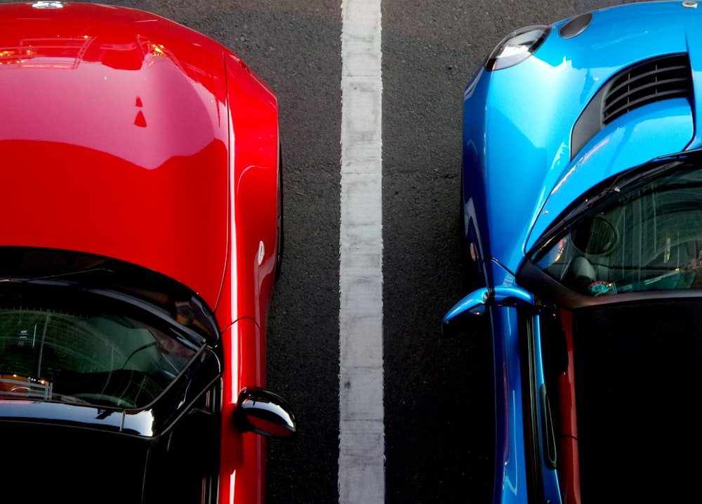 top view photo of red and blue convertibles on asphalt road