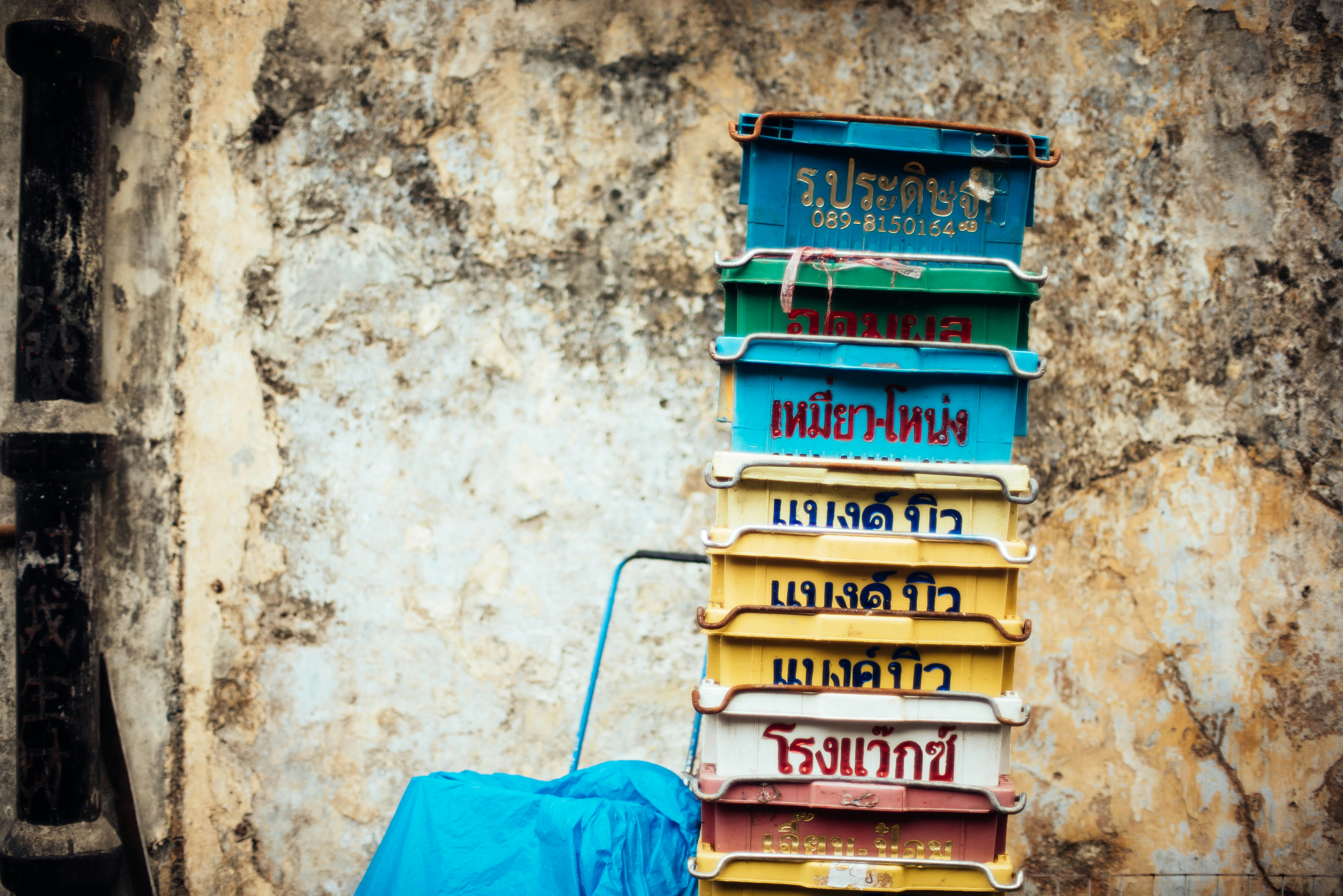 stack of assorted-color tubs near beige wall