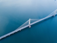 gray concrete bridge on body of water in aerial photography
