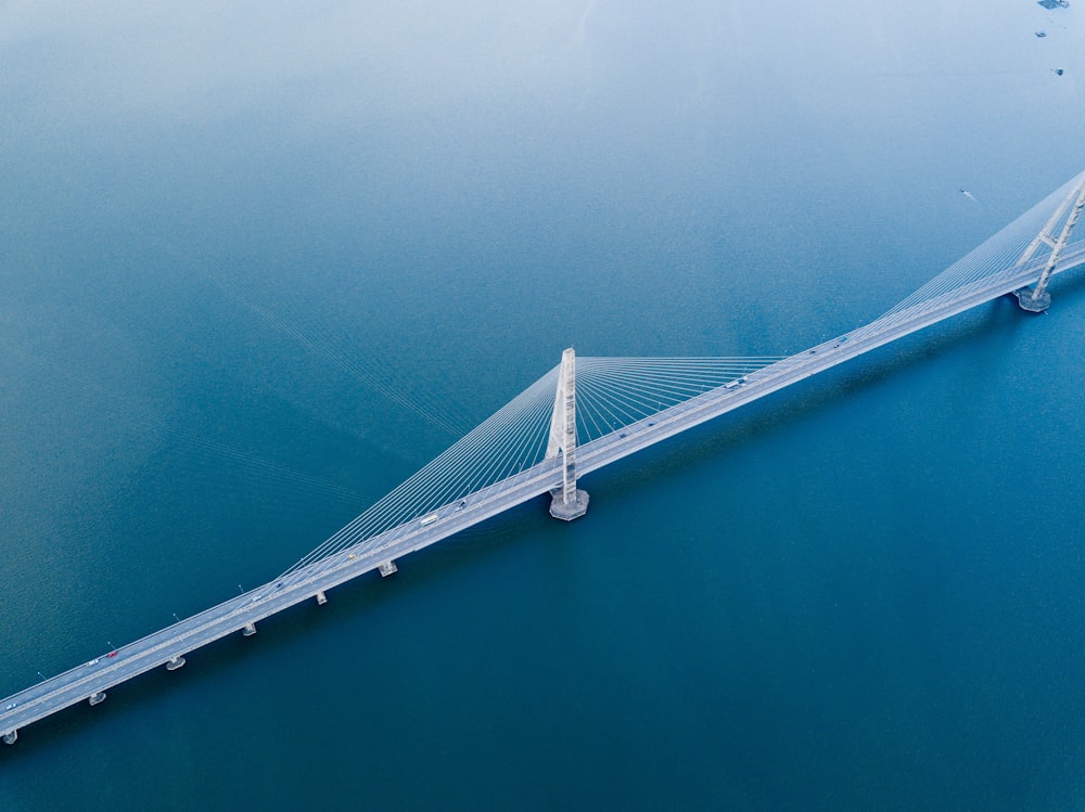 gray concrete bridge on body of water in aerial photography