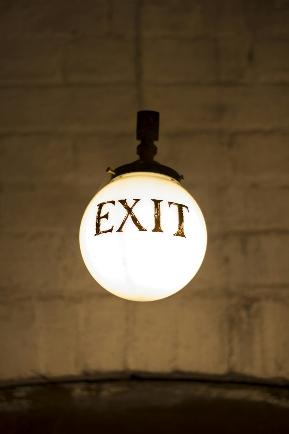 closeup photography of white hanging bulb light with exit signage