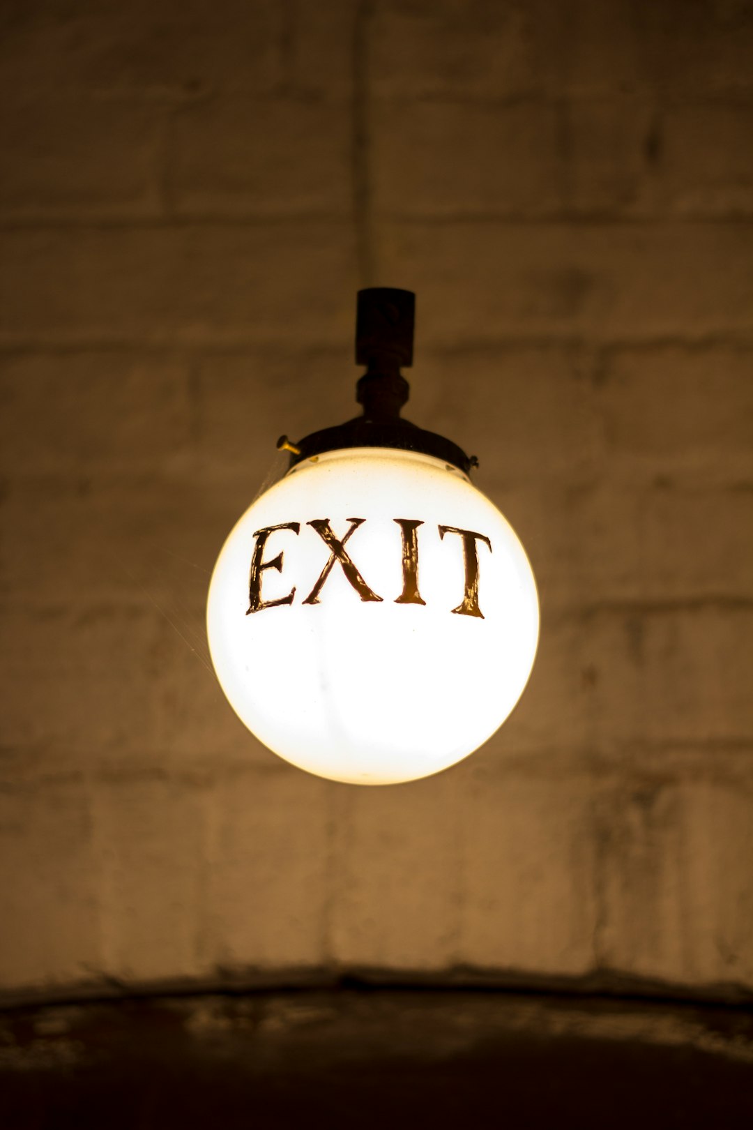 closeup photography of white hanging bulb light with exit signage