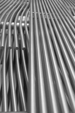 Industrial stainless steel curved pipes arranged neatly in a modern factory setting.