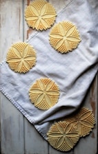 A beautifully engraved cookie with delicate patterns, displayed on a rustic table.