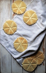A beautifully engraved cookie with delicate patterns, displayed on a rustic table.