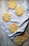 Close-up of delicately iced sugar cookies arranged on soft linen with blush floral accents.