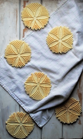 Delicate maamoul cookies filled with dates and decorated with intricate patterns on a ceramic dish.