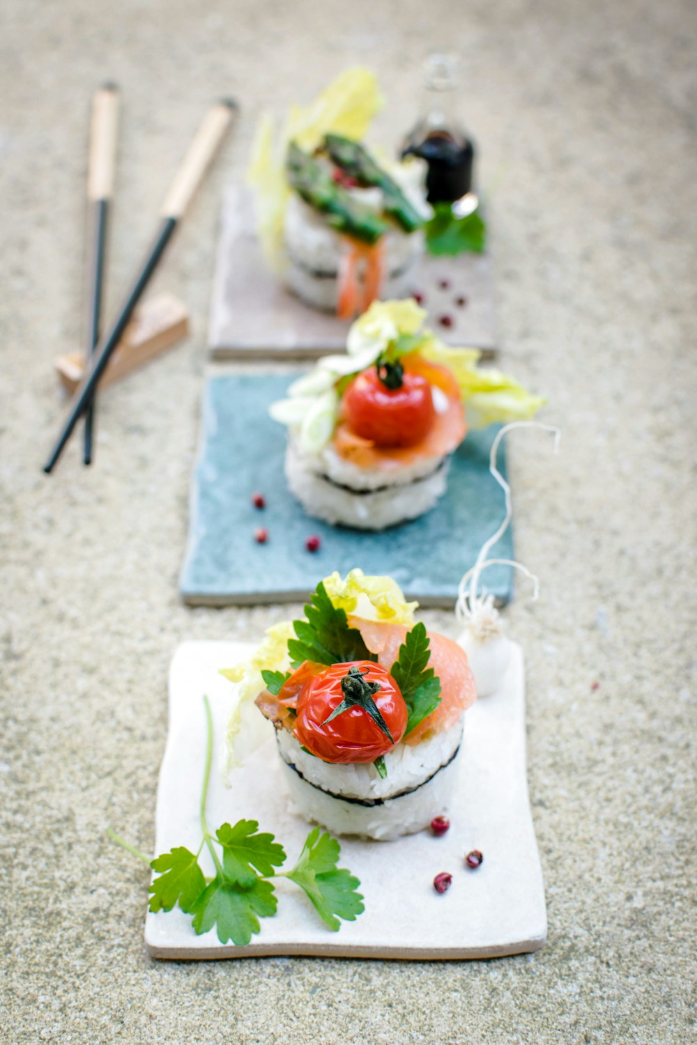 sushi con aderezos en pizarra blanca cerca de palillos