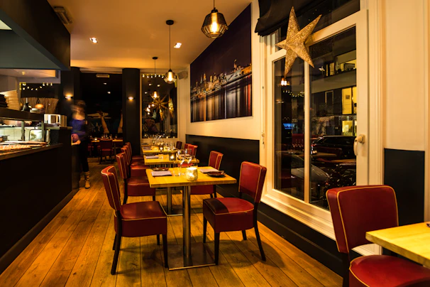 Cozy modern restaurant space with warm lighting and plated gourmet dishes.