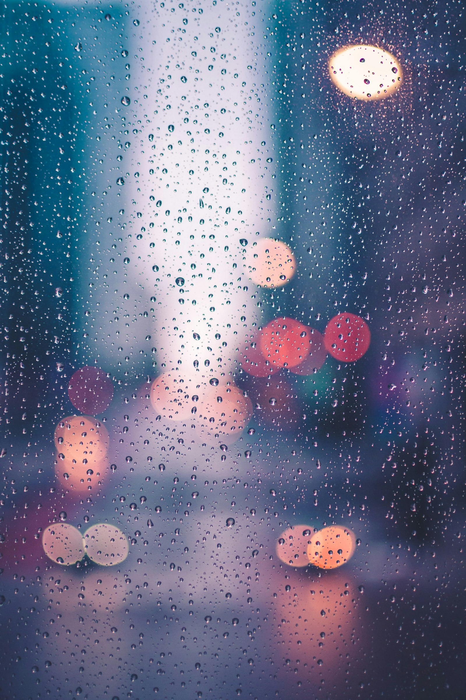 Headlights blurred through heavy rain on a road