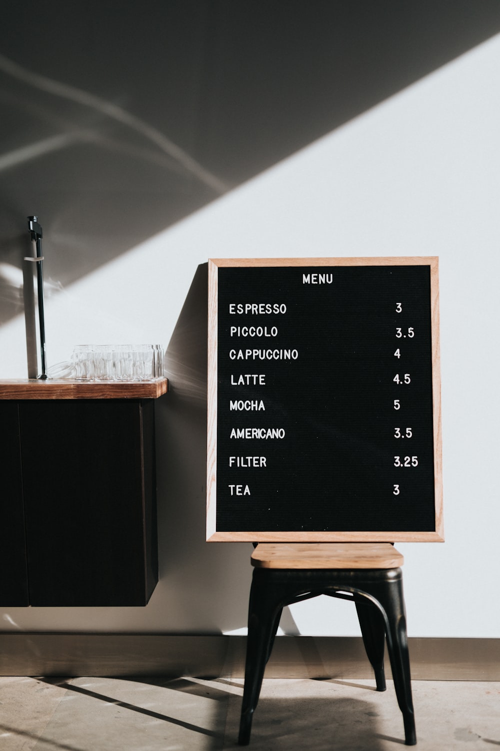 Menu board on metal chair near wooden countertop