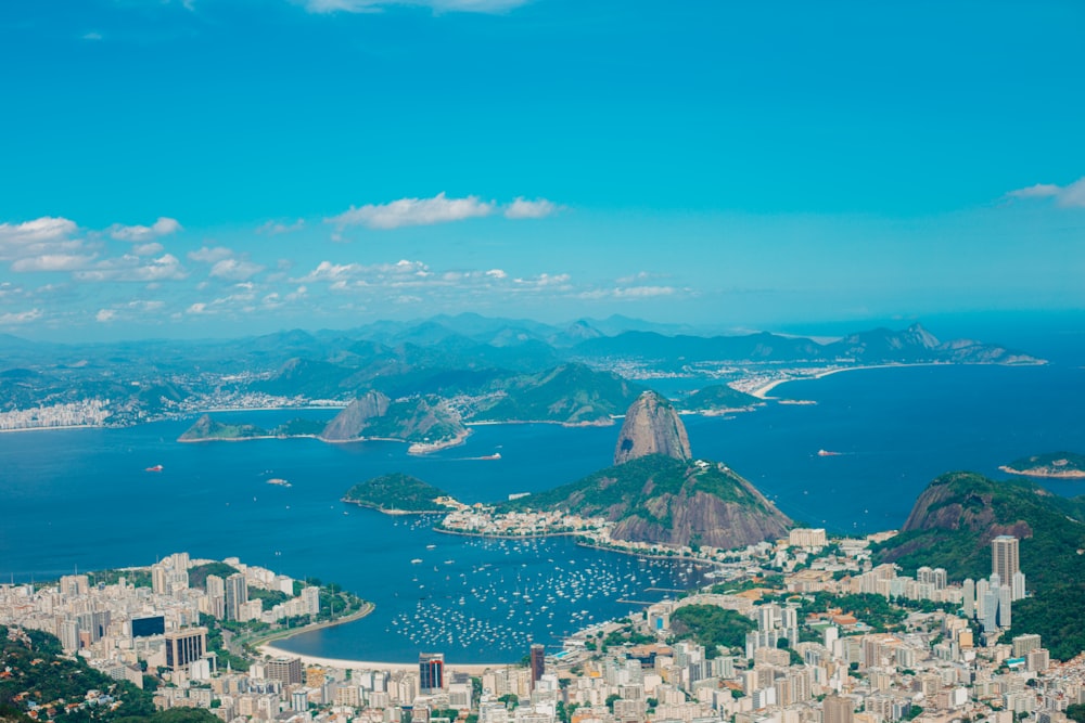 aerial photography of buildings near blue sea and mountains