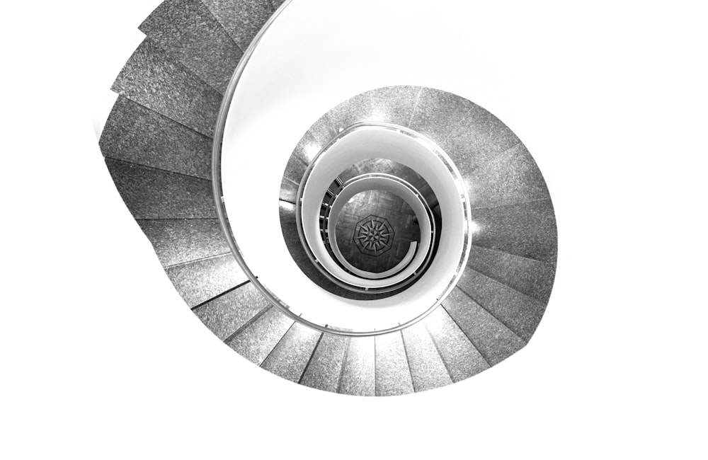 grayscale photography of spiral stairs with no people