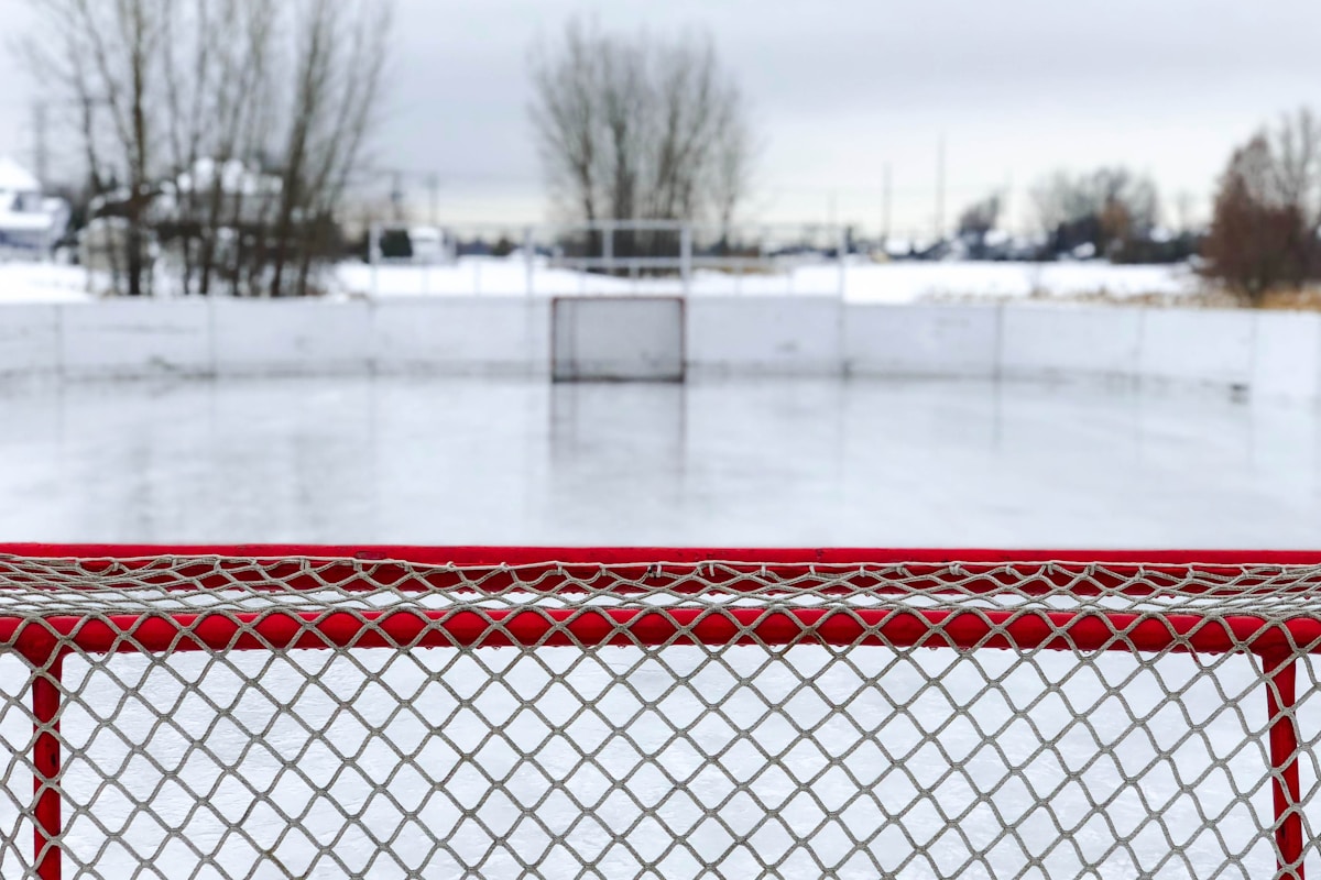 red and white goal net on ice field