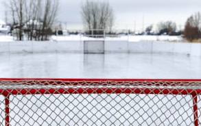 red and white goal net on ice field