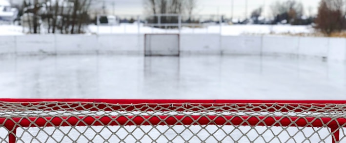 red and white goal net on ice field