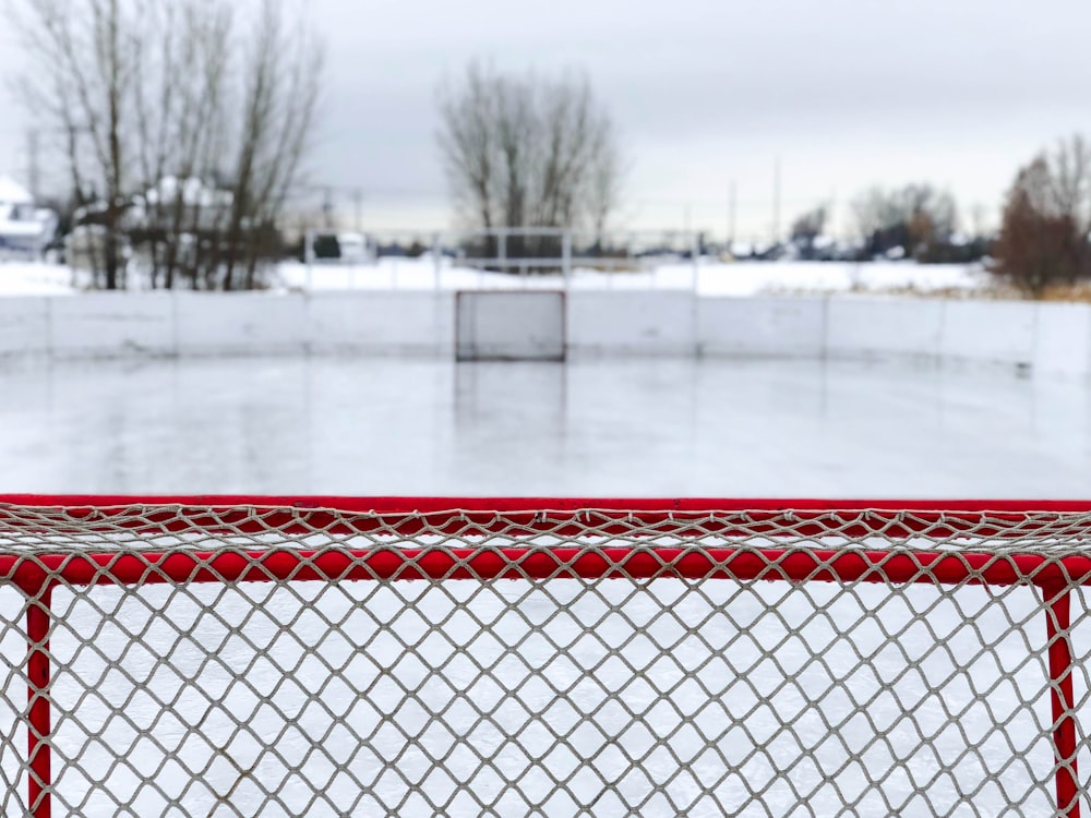 red and white goal net on ice field